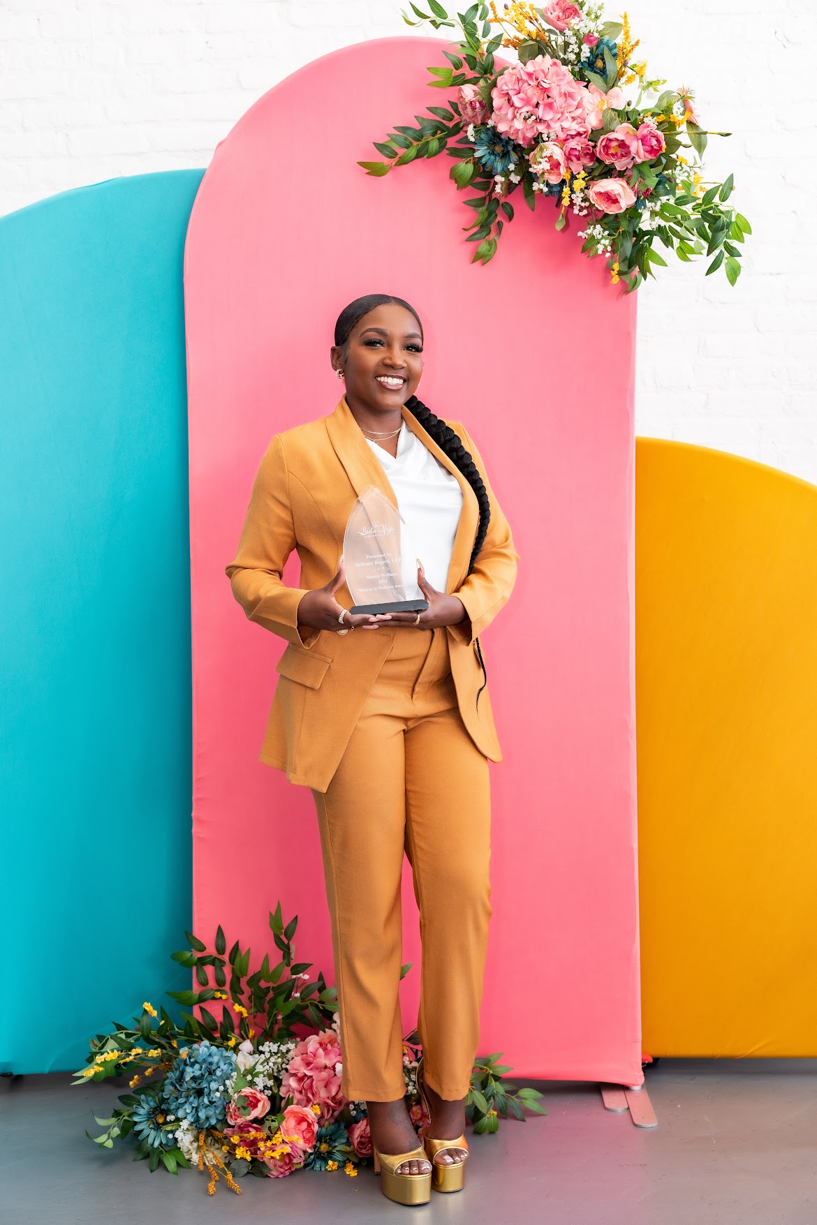Brittany Rogers smiling while holding an award